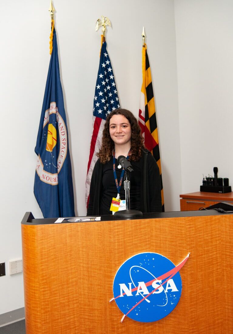 Celina smiling behind NASA podium