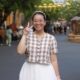 Ngan smiling in front of a blurry background. Her right hand is formed into the peace sign.